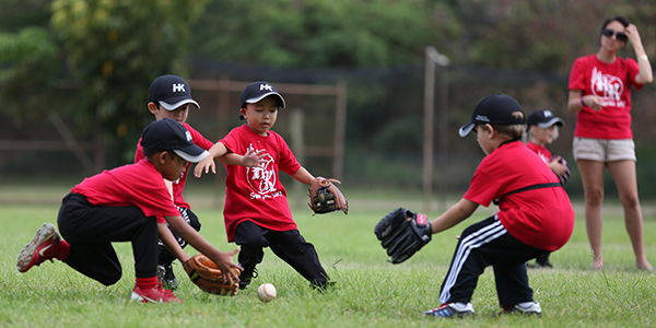 image of youth baseball players running to get ball